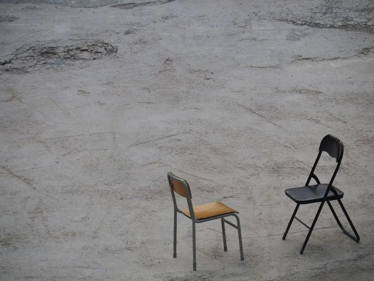 Minimalist photograph featuring two chairs on a concrete surface in Hong Kong.