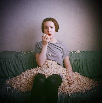 woman staring into space covered with popcorn