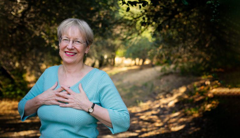 Ann Weiser Cornell standing in a forest