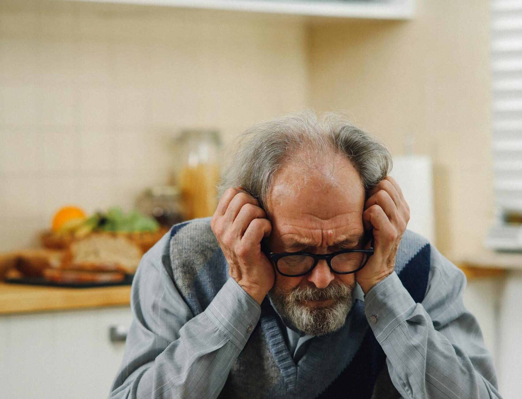 Close-Up Shot of an Elderly Man with Eyeglasses Looking at the Paper