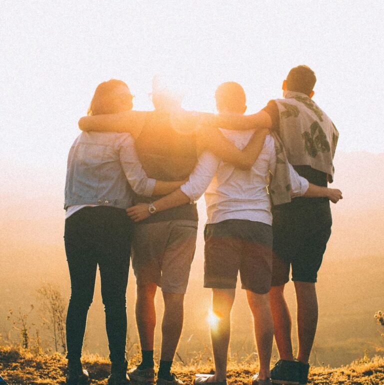 A group of friends embrace while enjoying a breathtaking sunrise over the Brazilian highlands.