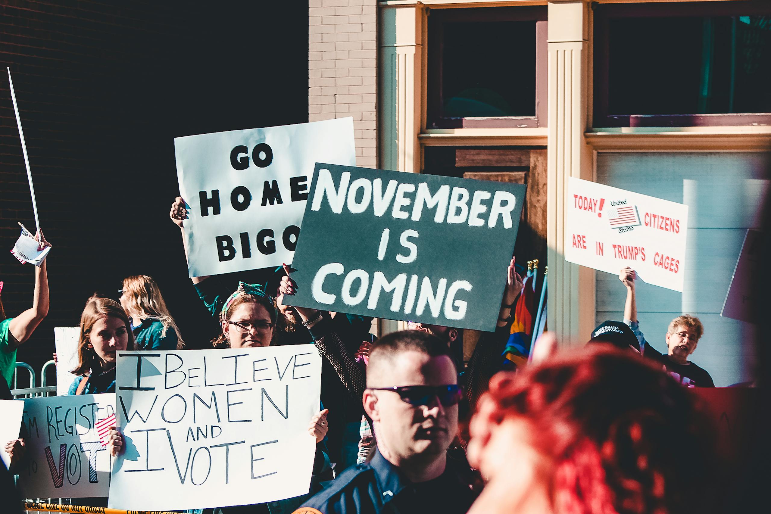 Dynamic street protest with diverse group holding impactful signs.