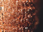 Closeup of textured backdrop with thin brown wavy wire with glowing surface on black background