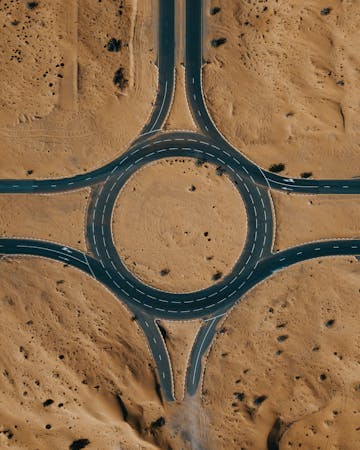 Top view of a desert roundabout surrounded by sand and roads.