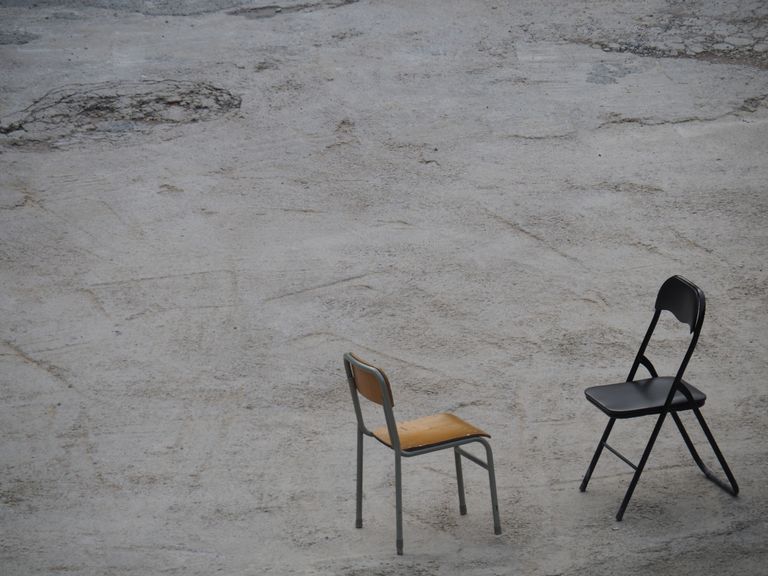 Minimalist photograph featuring two chairs on a concrete surface in Hong Kong.